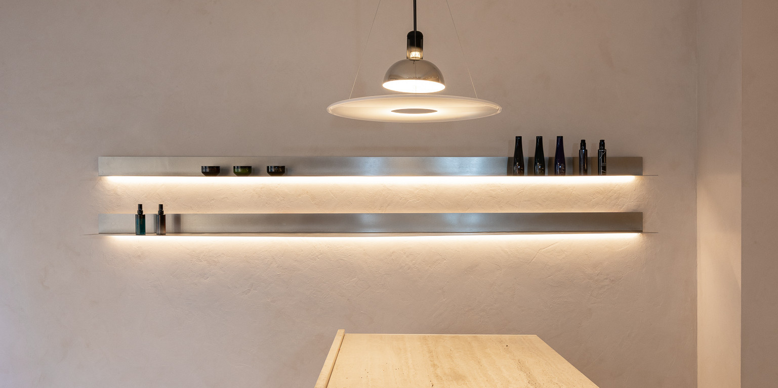 Backlit stainless steel shelves and pendant lamp at circlé salon, Bratislava