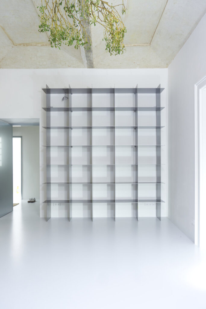 Custom Mesh stainless steel bookcase filling the end wall of a room