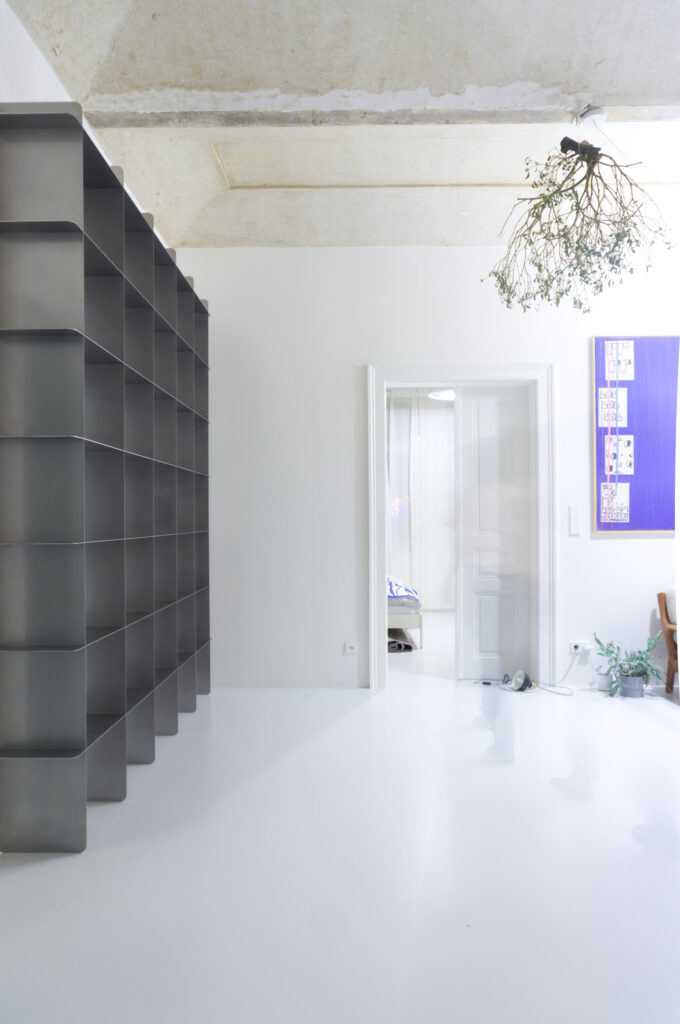 Custom Mesh stainless steel bookcase along the wall, seen at an angle